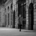 A girl walking in front of the Four Courts gates during a cold November night